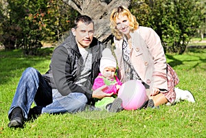 Small beautiful girl with parent on green glade