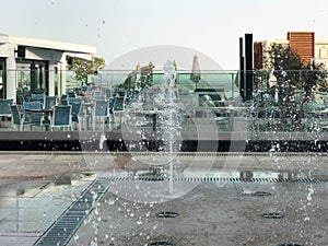 A small beautiful singing fountain in the open air, on the street. Drops of water, jets of water frozen in the air in flight