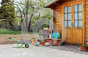 Small beautiful wooden house shed or storage hut for garden tools equipment and bicycles at backyard at beautiful