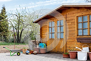 Small beautiful wooden house shed or storage hut for garden tools equipment and bicycles at backyard at beautiful