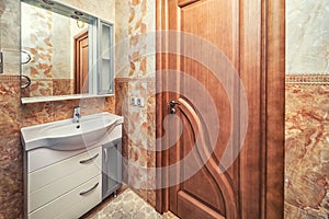 Small beige tile bathroom with sink and mirror