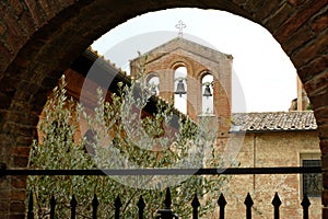 Small bell tower with three bells. Glimpse of the city of Siena in Tuscany. Brick brick building.  Stock photos. Siena, Tuscany,
