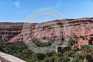 Small Berber village located in a green oasis valley with fields and palm trees , Morocco in the Atlas Mountains