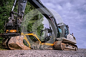 Small and big excavators at a construction site low angle view