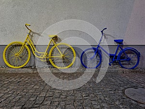Yellow and blue bike leaned againist the wall