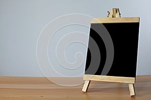 Small black board on wooden table,blank blackboard isolated