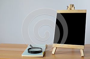 Small black board on wooden table,blank blackboard isolated