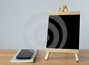 Small black board on wooden table,blank blackboard isolated