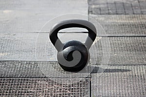 A small black weight weighing 16 kilograms stands on the rubber cover of the city stadium before the competition.