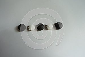 Small black and white pills in a row