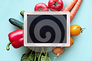 Small blackboard with vegetables around. Healthy concept with copy space.