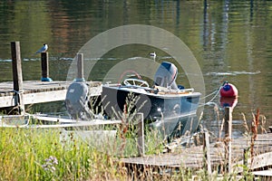 Small blue boat docked at wooded dock