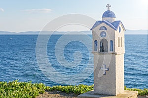 Small blue church near Neos Marmaras in Greece on summer with blue sea water in background