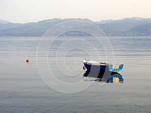 Small Blue Fishing Boat in Calm Sea Water