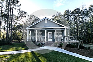 Small blue gray mobile home with a front and side porch with white railing
