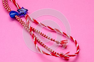 Small blue heart and star on red and white bakers twine with pink background