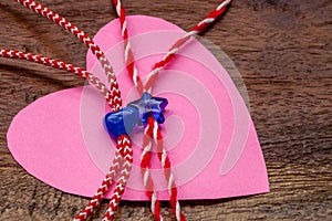 Small blue heart and star on red and white bakers twine with pink paper heart