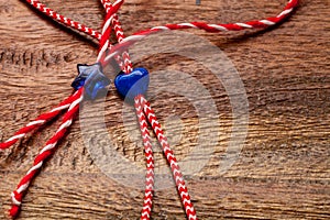 Small blue heart and star on red and white bakers twine with wooden background/International women`s day concept