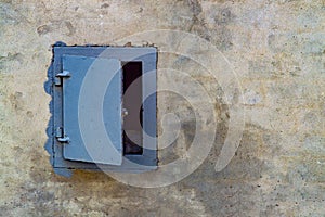 A small blue metal sunroof on the gray facade of a residential building.