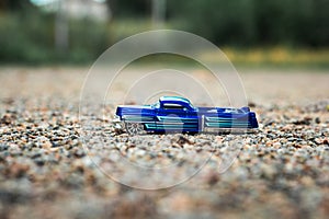 Small blue toy pickup truck on small marble rocks