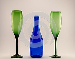 Small blue wine bottle and two green glasses