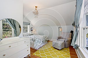 Small blue and yellow upstairs bedroom with vaulted ceiling and hardwood floor.