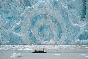 Small boat against glaciers in Inside Passage, Alaska