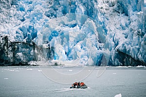 Small boat against glaciers in Inside Passage, Alaska