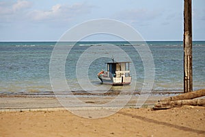 Small boat anchored on beach water edge photo