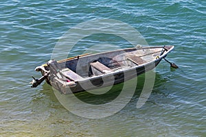 Small boat anchored, floating on the water.