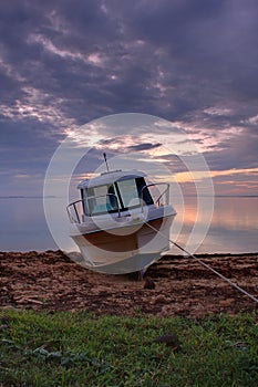 a small boat on a beach in tonga at dawn