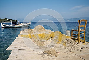 Small boat, chair and fishing nets in Greece
