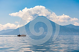 Small boat cruises past San Pedro Volcano, Lake Atitlan, Guatemala