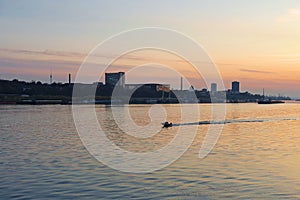 Small boat cruising Danube river at sunset