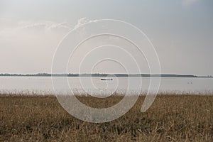 Small boat in middle of reservoir.