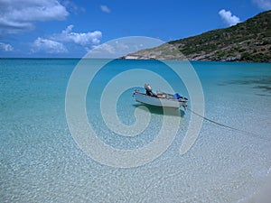 Small boat near a see through sea water beach