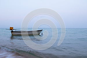 A small boat in the ocean with fishing boats in the distance off the coast of Cambodia
