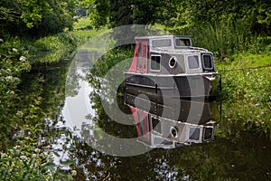 Small boat reflected in the canal water