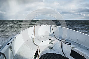 A small boat sailing in baltic sea with Paldiski, Estonia port in background.