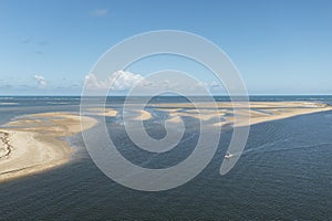 Small boat sailing in place where the river meets the sea