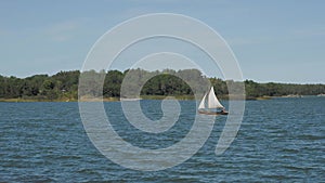 Small boat with sails floats on the river
