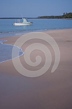 A small boat on the sea during a sunset