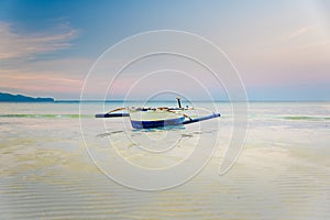Small boat at the shore of Boracay, Philippines during early morning low tide