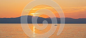 Small boat silhouette float on sea with sunset sky and distant hill. Travel, sport background, Croatia, island Krk