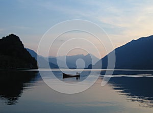 Small boat on still waters of Brienzersee, Switzerland at sunset