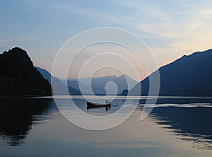 Small boat on still waters of Brienzersee, Switzerland at sunset photo