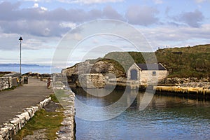 The small boathouse and slipway at Ballintoy harbor on the North Antrim Coast of Northern Ireland with its stone built boathouse o