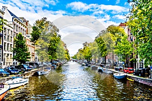 Small boats, cars and bikes lining the Herengracht, or Gentlemen`s Canal, in the historic center of Amsterdam