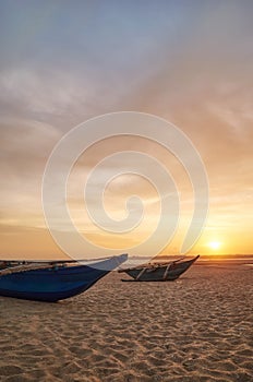 Small boats on an empty beach at sunset, Sri Lanka