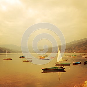 Small boats on the lake - vintage effect. Colorful retro photo.
